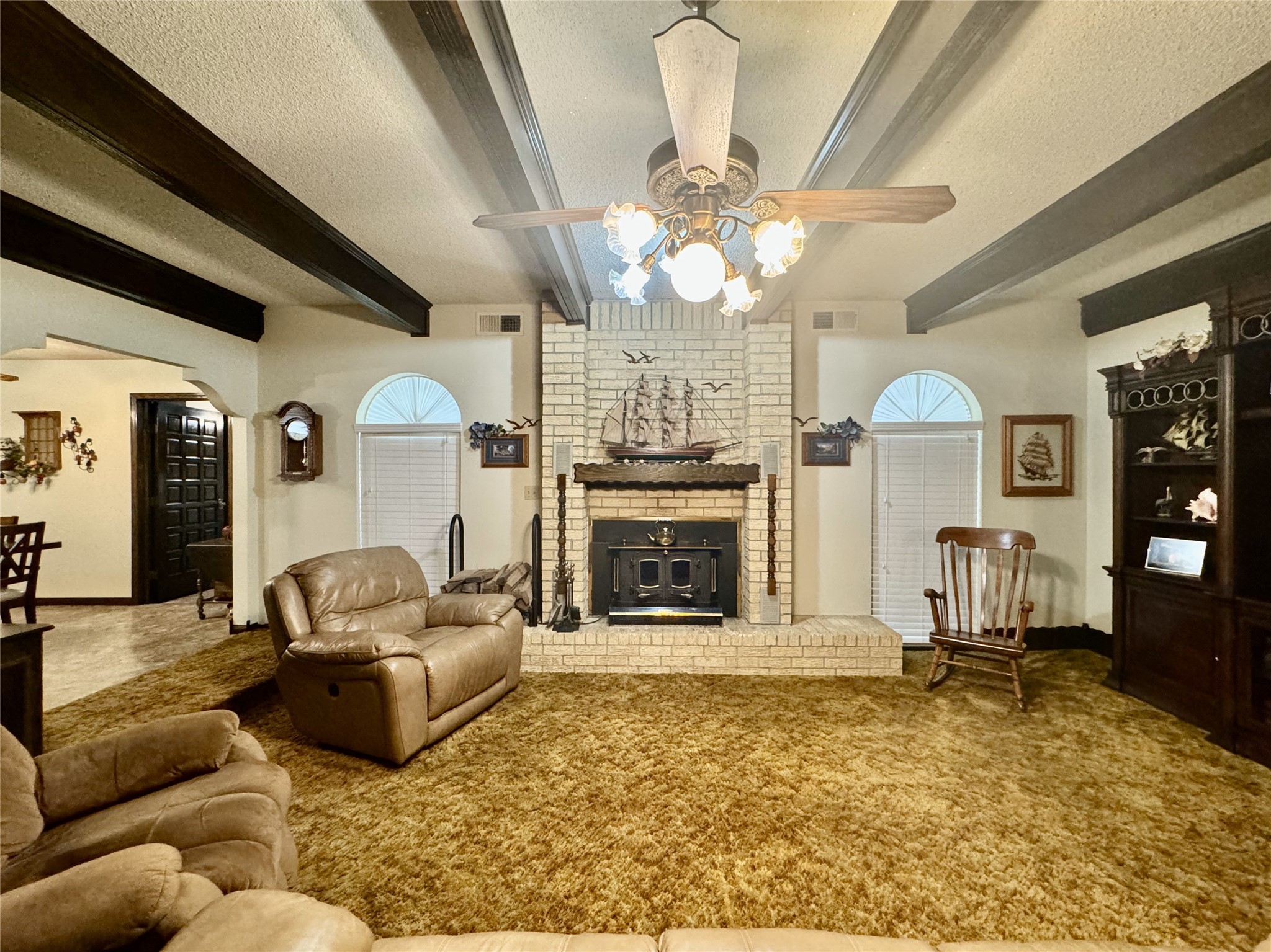 11586 Midway Road Cleveland, TX 77328 - Photo 6 of 37 a living room with furniture a fireplace and a chandelier