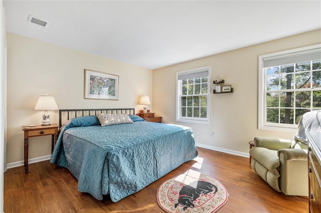 2375 Fairhill Farms Road Sewickley, PA 15143 - Photo 16 of 25 a spacious bedroom with a bed a couch and a window with wooden floor