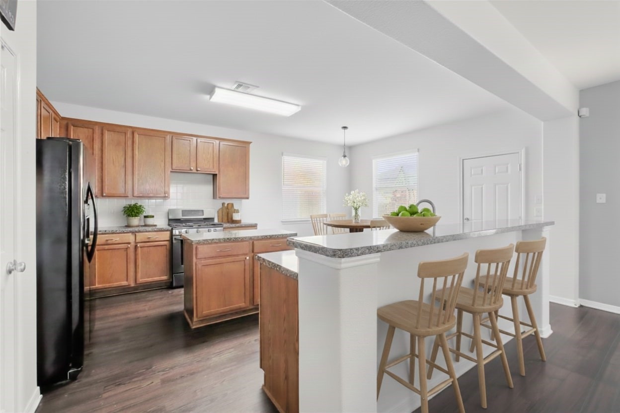 1193 Stallion Ridge Alvin, TX 77511 - Photo 4 of 14 a kitchen with white cabinets and stainless steel appliances
