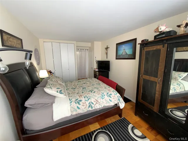 a bedroom with a bed and wooden floor