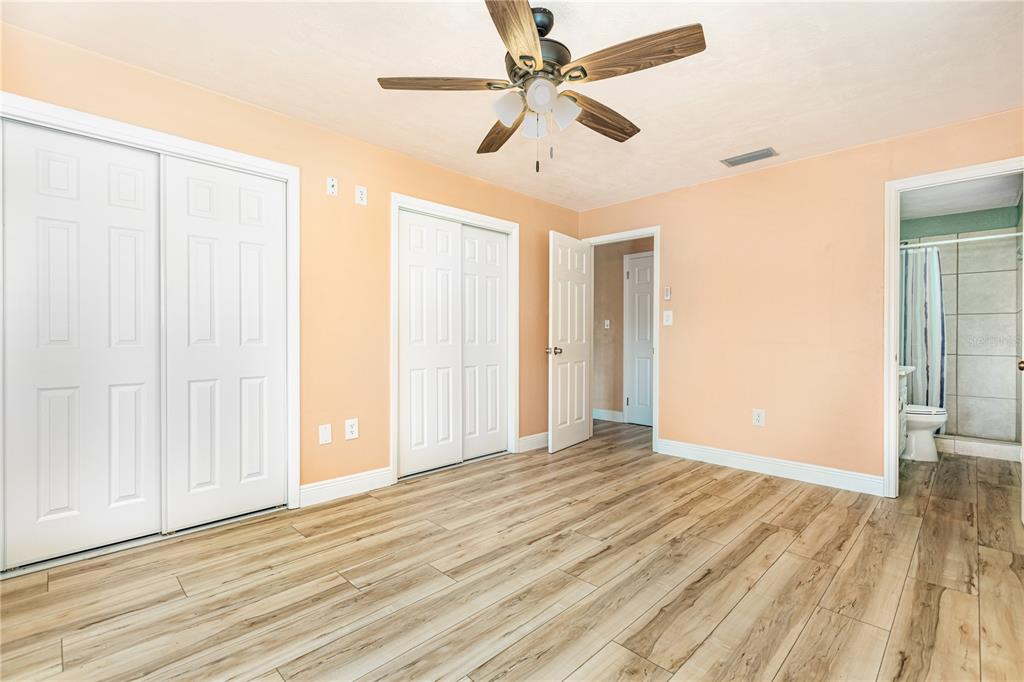 5108 Commonwealth Road Palmetto, FL 34221 - Photo 13 of 31 an empty room with wooden floor fan and windows