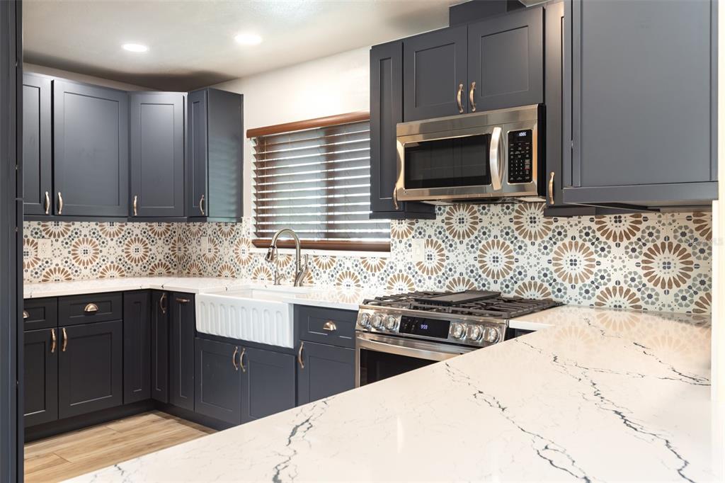 5108 Commonwealth Road Palmetto, FL 34221 - Photo 7 of 31 a kitchen with stainless steel appliances kitchen island granite countertop a sink stove and microwave