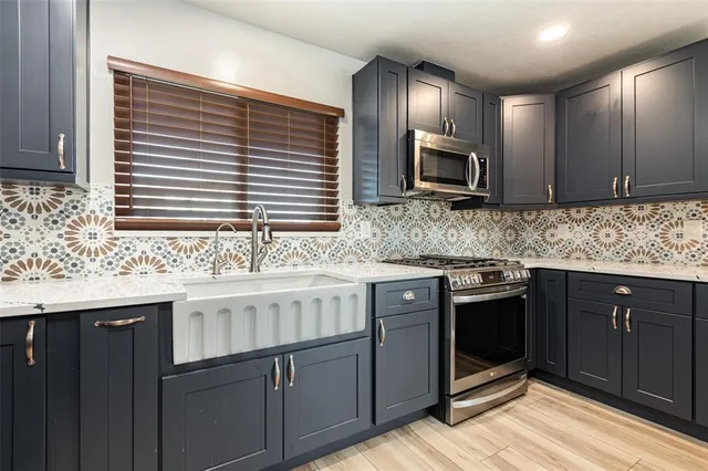 a kitchen with stainless steel appliances granite countertop wooden cabinets a sink and a stove