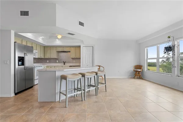 a kitchen with kitchen island white cabinets and refrigerator