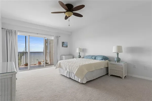 a spacious bedroom with a bed a chandelier and a window