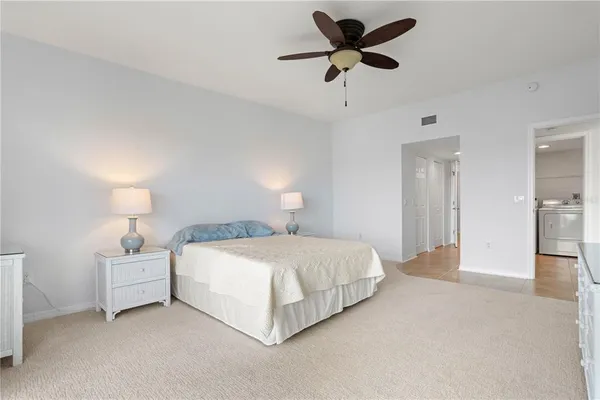 a bedroom with a bed chandelier and a window