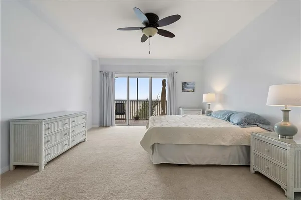 a spacious bedroom with a bed and a chandelier