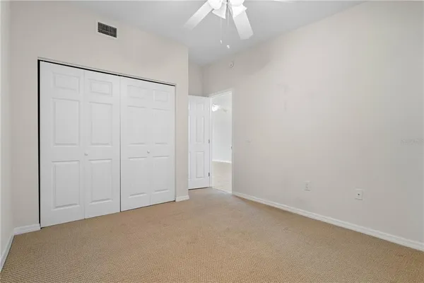an empty room with a ceiling fan and natural light