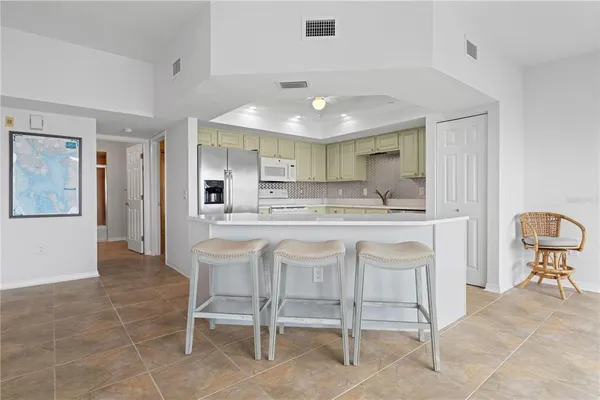 a kitchen with kitchen island granite countertop wooden cabinets and white appliances