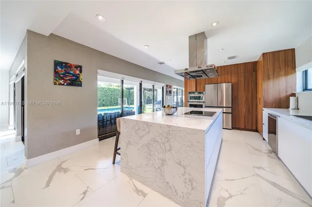 a kitchen with kitchen island a stove a refrigerator and a sink with wooden cabinets