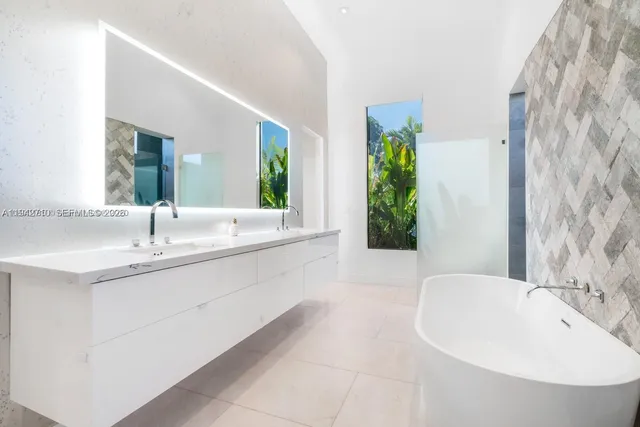 a view of a house with a big yard plants and large trees