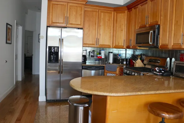 a kitchen with stainless steel appliances granite countertop a refrigerator a stove top oven a sink and dishwasher