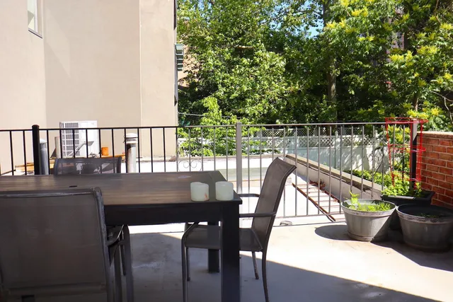a view of a balcony with chairs and wooden floor