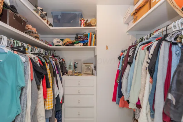 a view of walk in closet with clothes and shoes