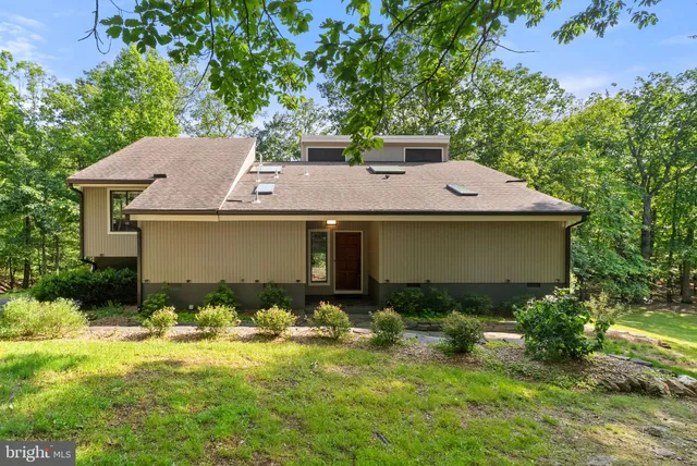 a living room with furniture a large window and a fireplace