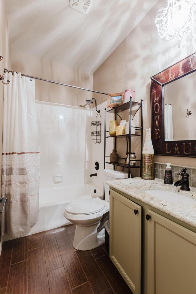 10819 Crown Colony Drive, Unit 40 Austin, TX 78747 - Photo 25 of 38 Full bathroom featuring shower / bath combination with curtain, vanity, wood finish floors, and lofted ceiling