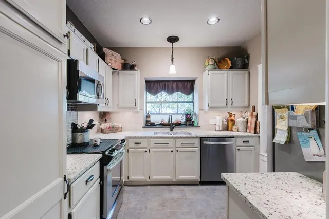 a kitchen with a sink stove and cabinets