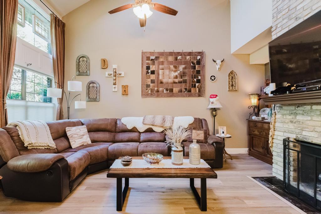 10819 Crown Colony Drive, Unit 40 Austin, TX 78747 - Photo 9 of 38 Living room with wood finished floors, a brick fireplace, lofted ceiling, and a ceiling fan