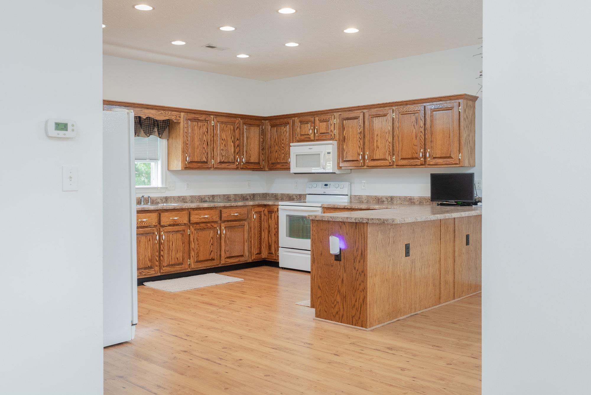 490 Leola Loop Stanley, VA 22851 - Photo 7 of 44 a kitchen with kitchen island granite countertop wooden cabinets and white appliances