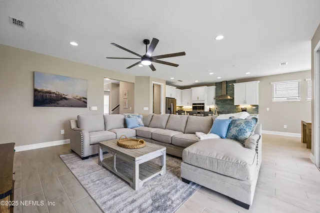 a living room with furniture kitchen view and a flat screen tv
