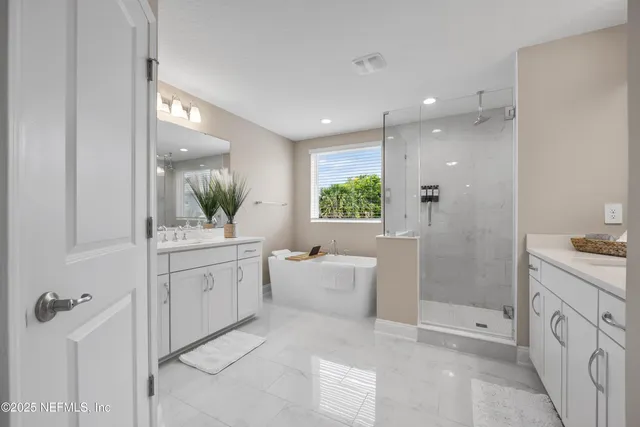 a bathroom with a granite countertop sink mirror and bathtub