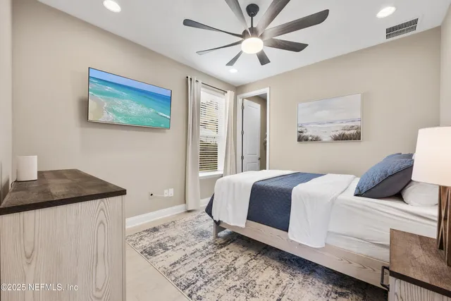 a bedroom with a large bed and a chandelier