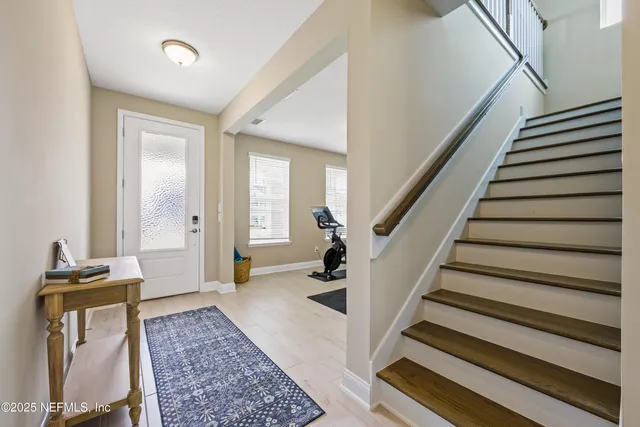 a view of a hallway with wooden floor and stairs