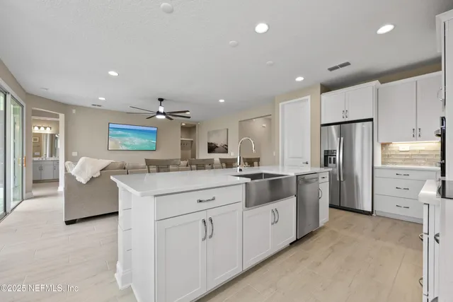 a kitchen with white cabinets and stainless steel appliances