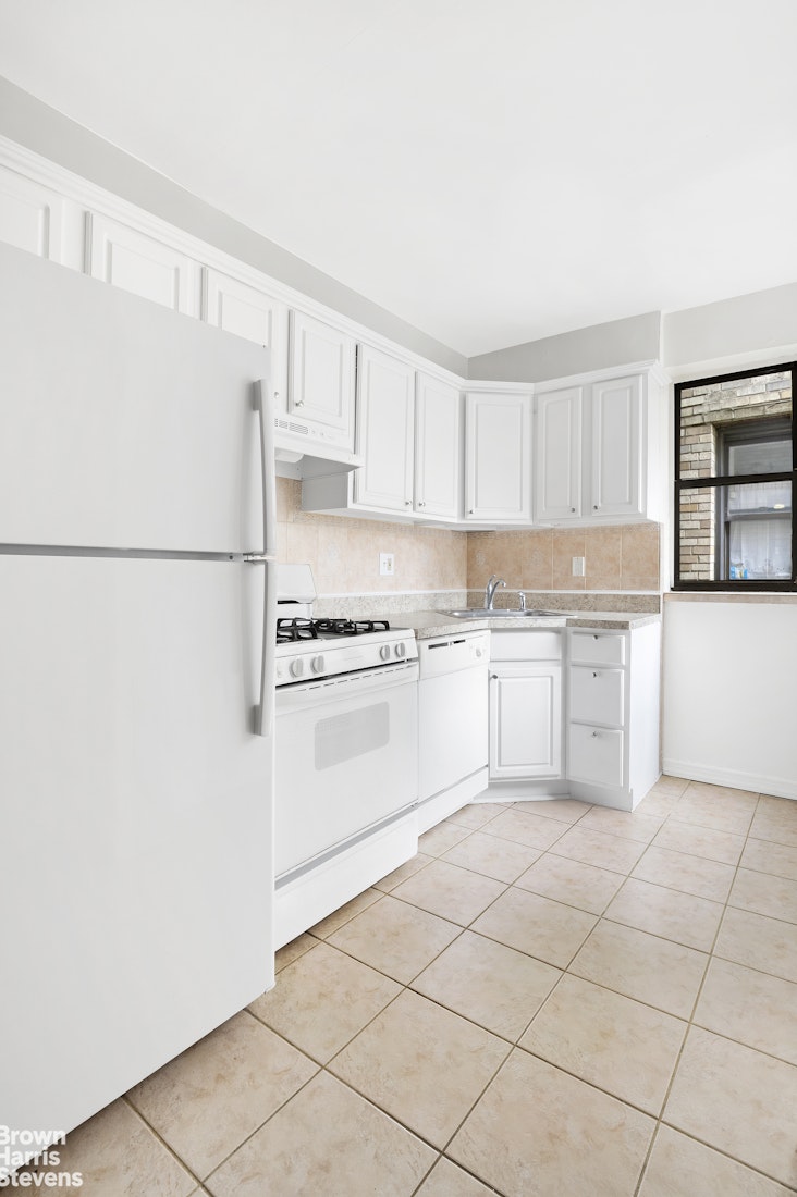 55 East 190th Street, Unit 41 Bronx, NY 10468 - Photo 8 of 8 a kitchen with cabinets and white appliances
