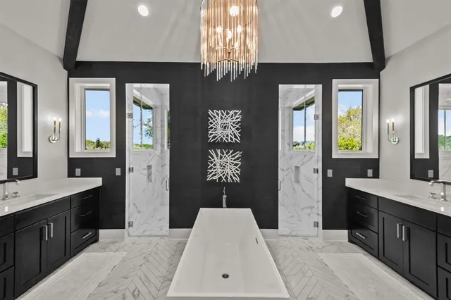 a spacious bathroom with a granite countertop sink a large mirror and a bathtub