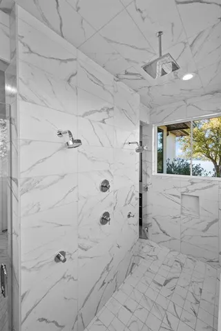 a spacious bathroom with a granite countertop sink a mirror and a shower