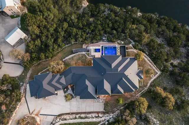 an aerial view of a house with swimming pool and red chairs