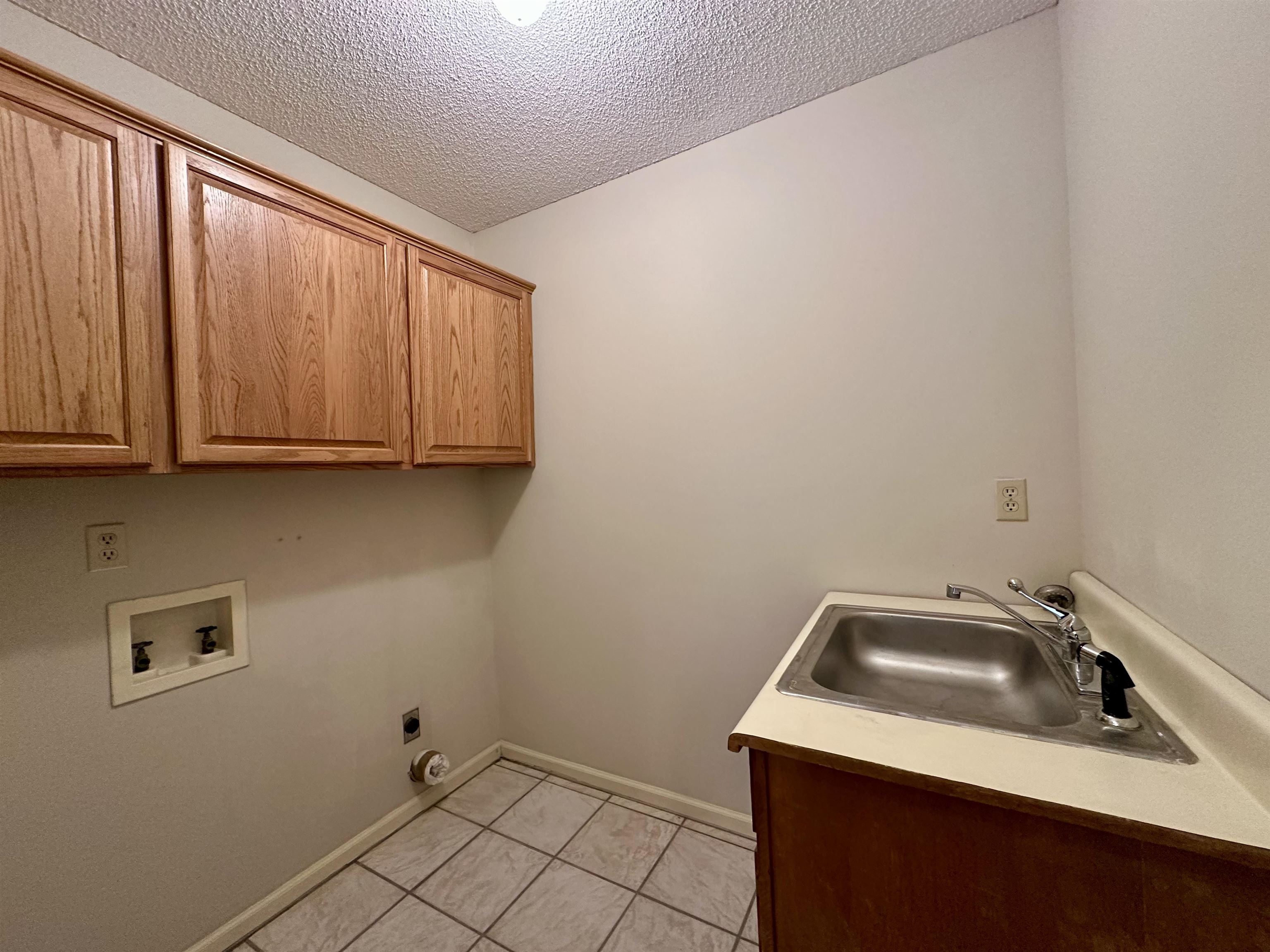 3365 Tomlin Road Somerville, TN 38068 - Photo 25 of 35 Laundry area featuring cabinet space, a textured ceiling, hookup for a washing machine, light tile patterned flooring, and electric dryer hookup