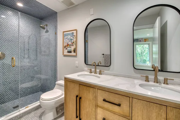 a bathroom with a double vanity sink toilet and shower