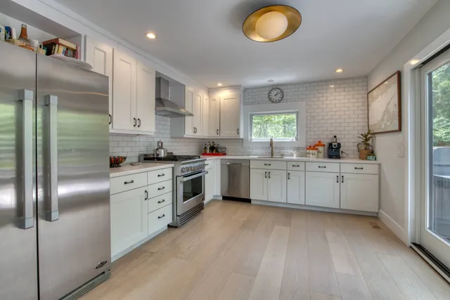 a kitchen with white cabinets and white appliances