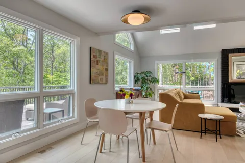 a view of a dining room with furniture a rug and wooden floor
