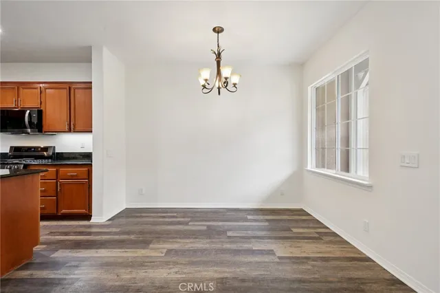 a view of a room with wooden floor ceiling fan and windows
