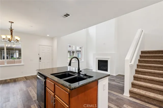 a kitchen with sink a stove and wooden floor