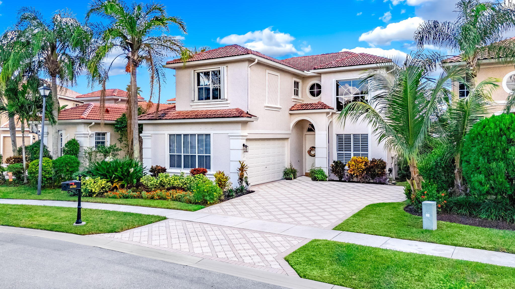 a front view of a house with a yard and potted plants