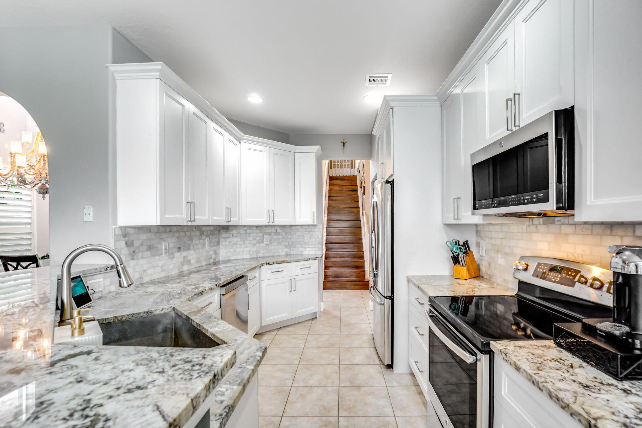 9760 Vineyard Court Boca Raton, FL 33428 - Photo 21 of 75 a kitchen with granite countertop a refrigerator and a sink