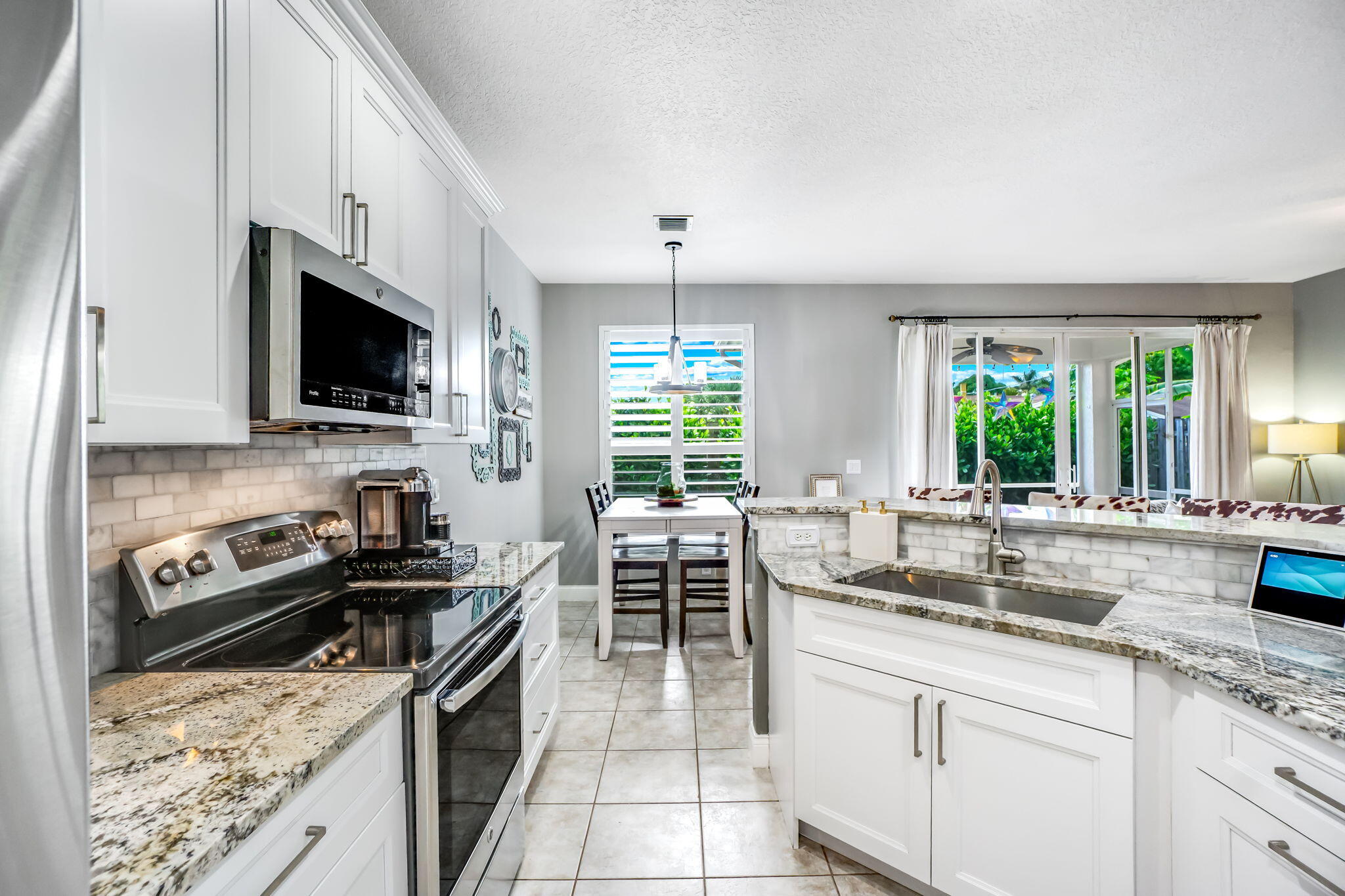 9760 Vineyard Court Boca Raton, FL 33428 - Photo 23 of 75 a kitchen with stainless steel appliances granite countertop a stove top oven a sink a counter space and cabinets