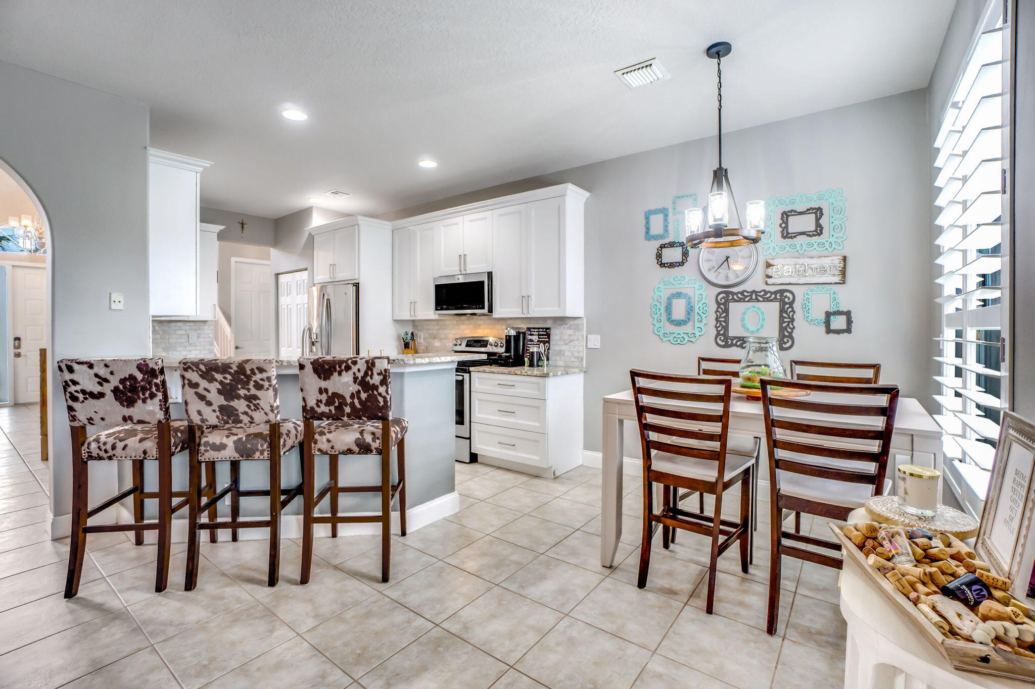 9760 Vineyard Court Boca Raton, FL 33428 - Photo 26 of 75 a kitchen with stainless steel appliances kitchen island granite countertop a stove a sink a chairs and a dining table