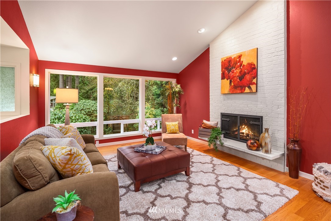 22918 38th Avenue Southeast Bothell, WA 98021 - Photo 3 of 28 a living room with furniture a fireplace and a floor to ceiling window