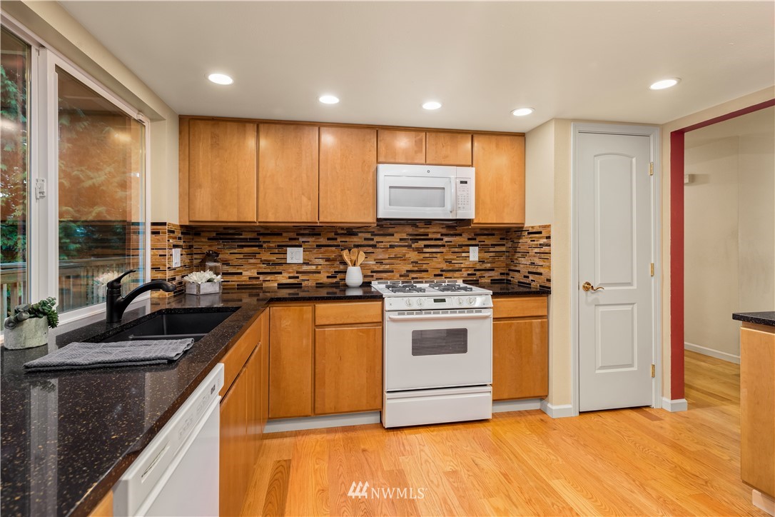 22918 38th Avenue Southeast Bothell, WA 98021 - Photo 9 of 28 a view of a kitchen with kitchen island a sink a counter top space and stainless steel appliances