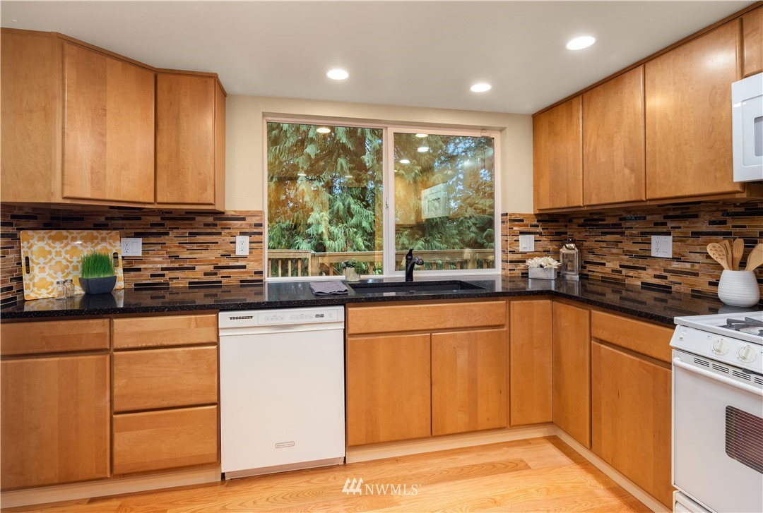 22918 38th Avenue Southeast Bothell, WA 98021 - Photo 10 of 28 a kitchen with stainless steel appliances granite countertop wooden cabinets a sink and a large window