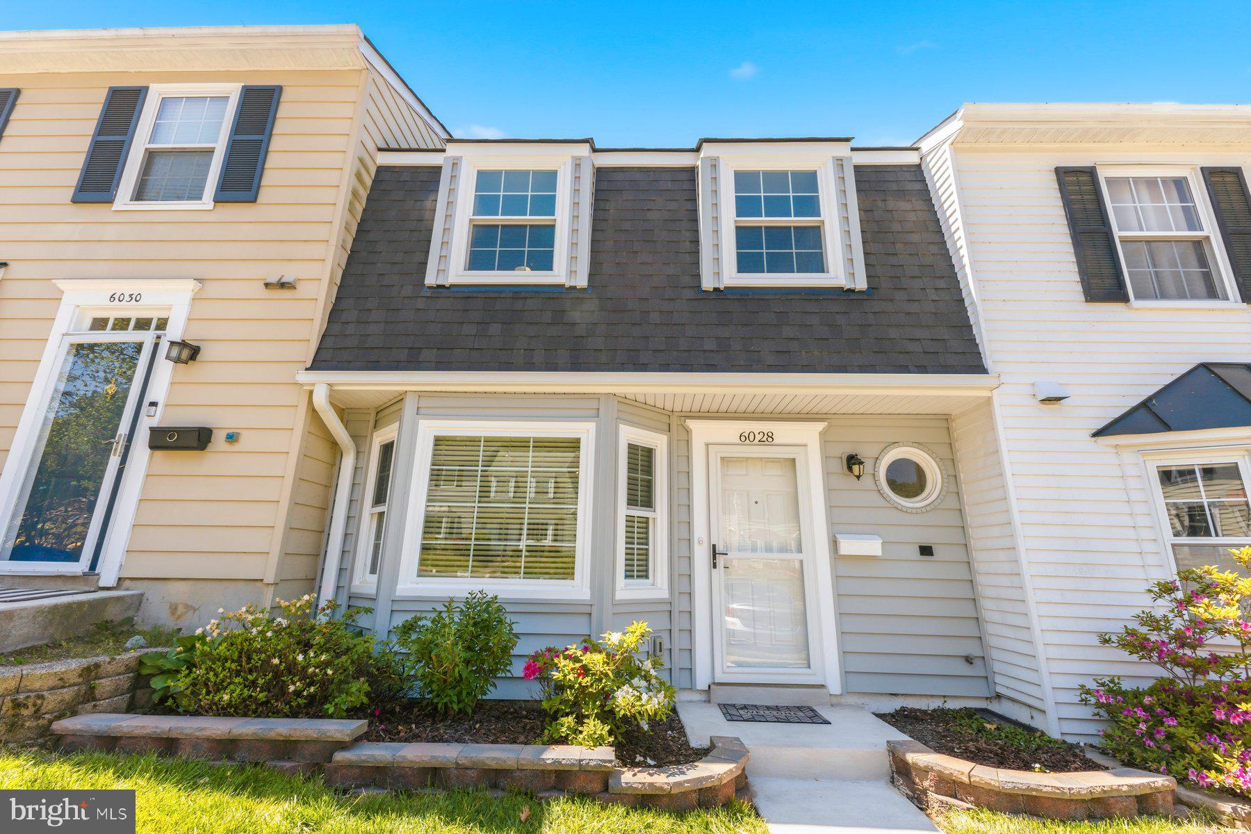 a front view of a house with a yard and outdoor seating