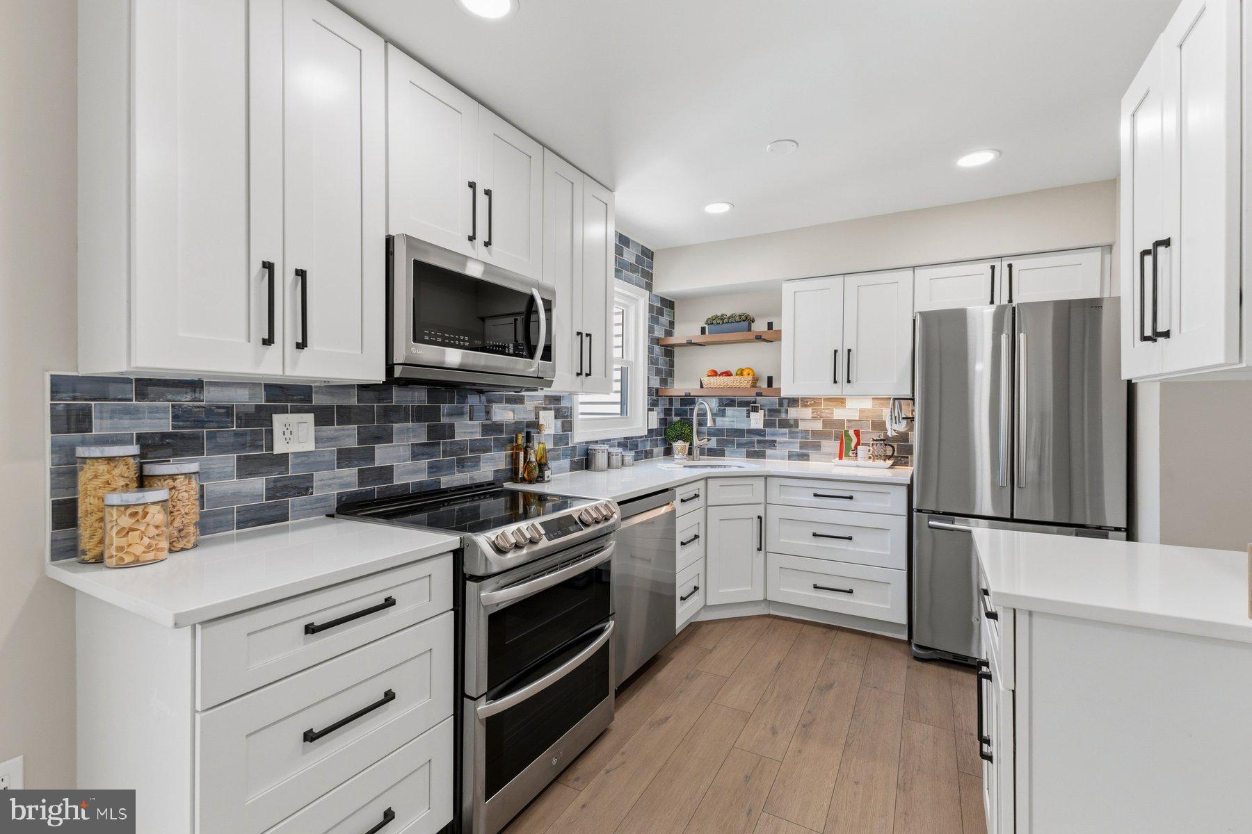 6028 Sweet Dale Court Springfield, VA 22152 - Photo 10 of 29 a kitchen with stainless steel appliances a stove microwave and cabinets