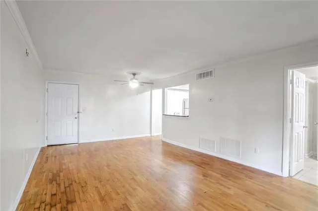 a view of empty room with wooden floor