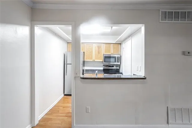 a view of kitchen with wooden floor and cabinets