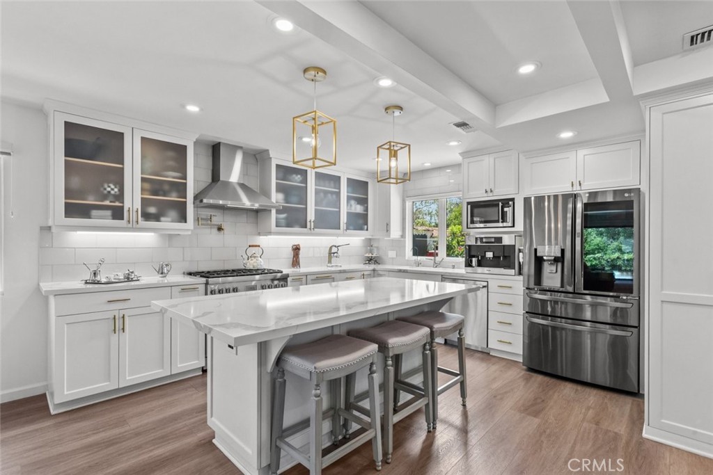 2534 Page Drive Altadena, CA 91001 - Photo 12 of 48 a kitchen with stainless steel appliances granite countertop a stove a sink dishwasher a refrigerator and white cabinets with wooden floor